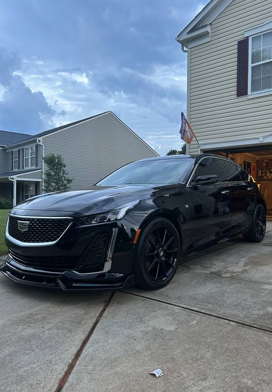 Mobile ceramic coating in Charlotte: Black Cadillac CT5 with glossy paint and black wheels in a driveway after a detail