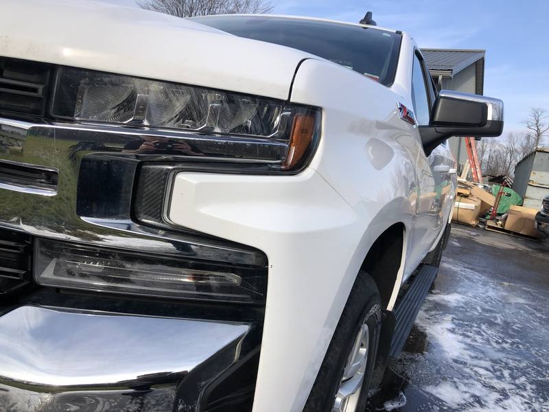 Mobile wash and wax in Charlotte: Front of a white Chevy Silverado Z71 with glossy paint and chrome grille after a wash