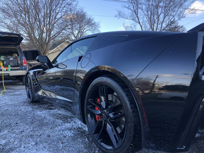 Mobile wash and wax in Charlotte: Black C7 Corvette Stingray with glossy paint reflecting the sky after a detail