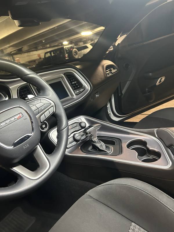 Mobile interior detailing in Charlotte: Dodge Challenger dashboard, steering wheel, and center console after an interior detail