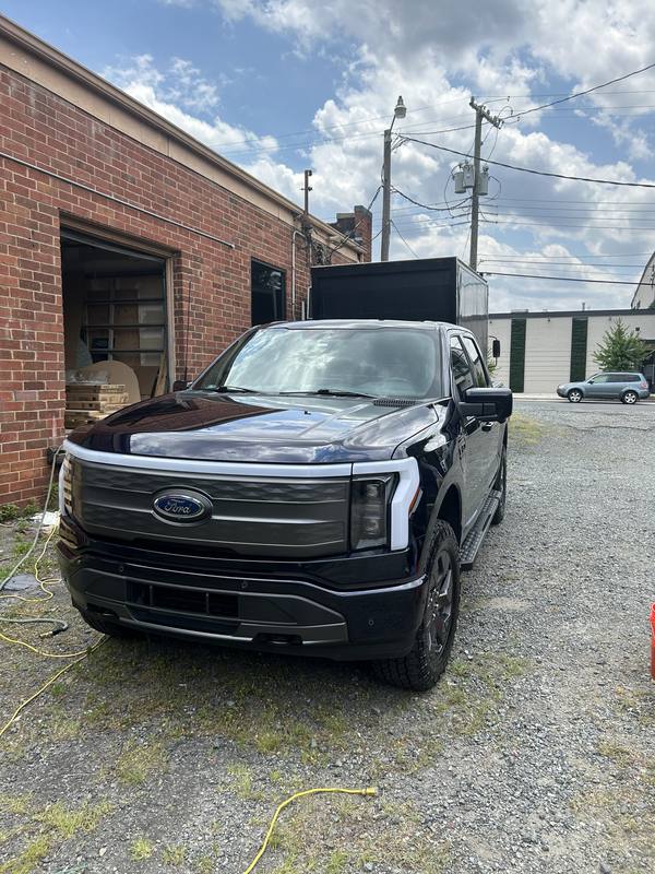 Mobile exterior detailing in Charlotte: Front of a dark blue Ford F-150 Lightning with glossy paint after a wash
